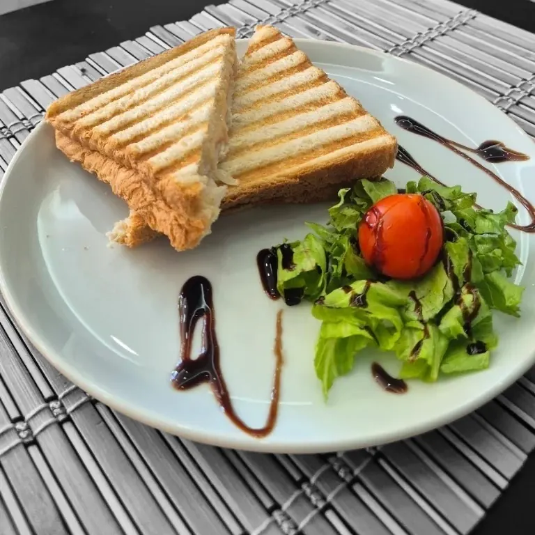 A toasted sandwich with salad and balsamic